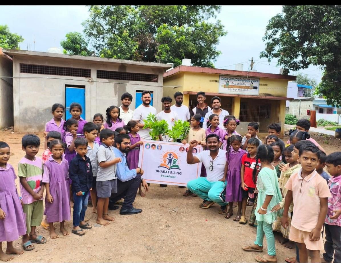 Foundation volunteers and schoolchildren holding a Bharat Rising Foundation banner and saplings
